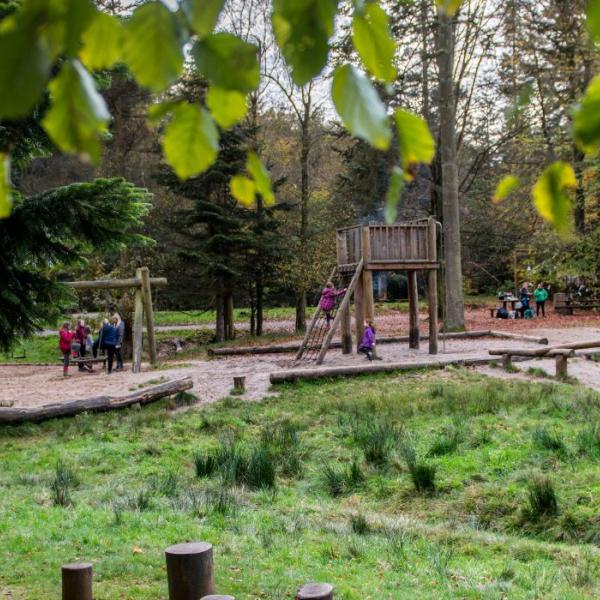 Family plays on the nature playground in Sønderskoven