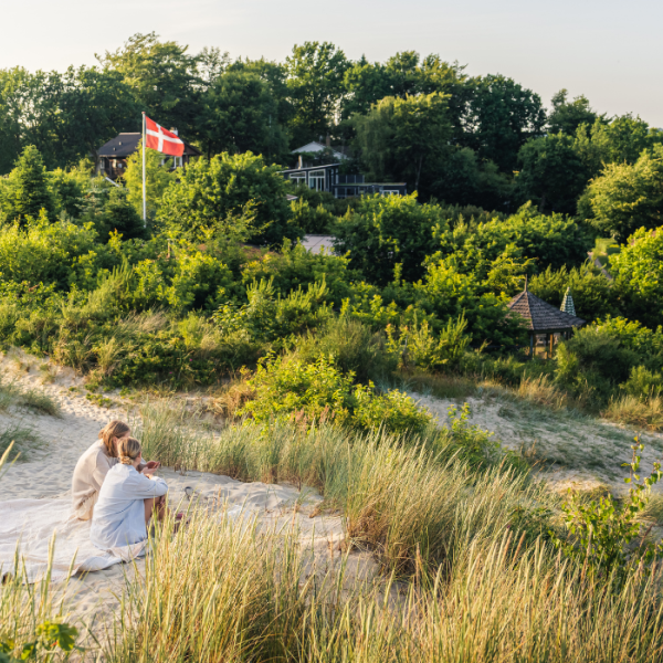Women sit on the sand dune at Hvidbjerg Beach in Vejle