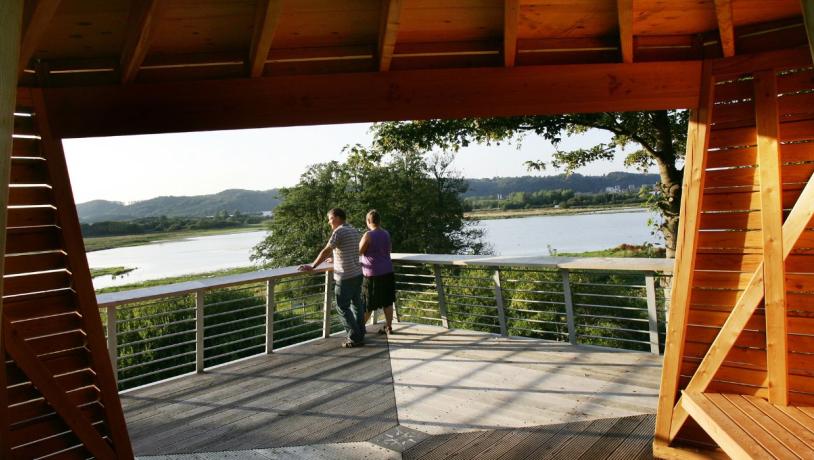 A couple stands and enjoys the view from the observation tower in Kongens Kær in Vejle