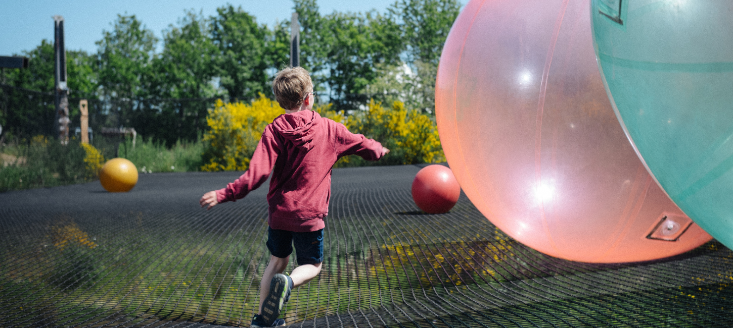 Boy jumps in WOW PARK on big trampoline with big bouncy balls