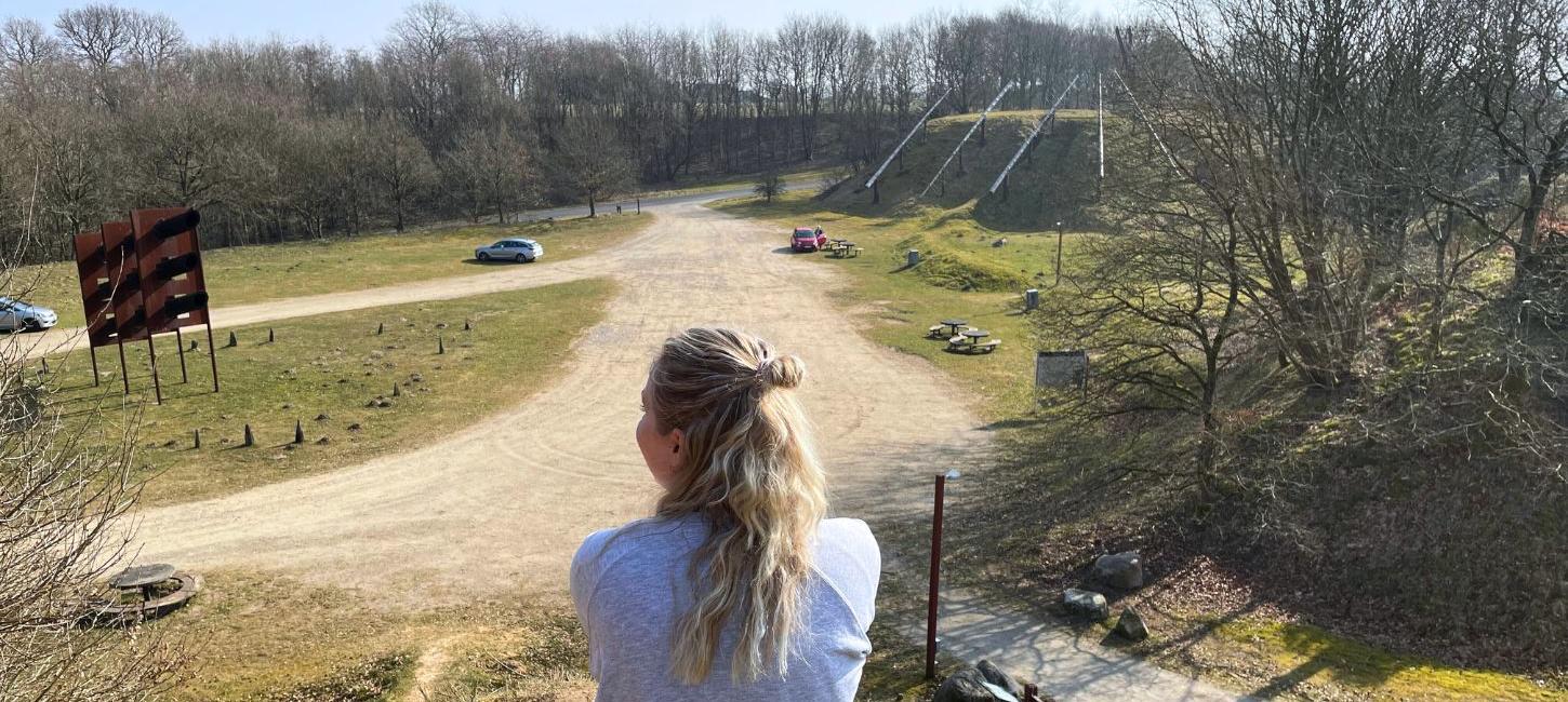 Person holder pause ved Tørskind Grusgrav og nyder udsigten over grusgraven og skulpturen