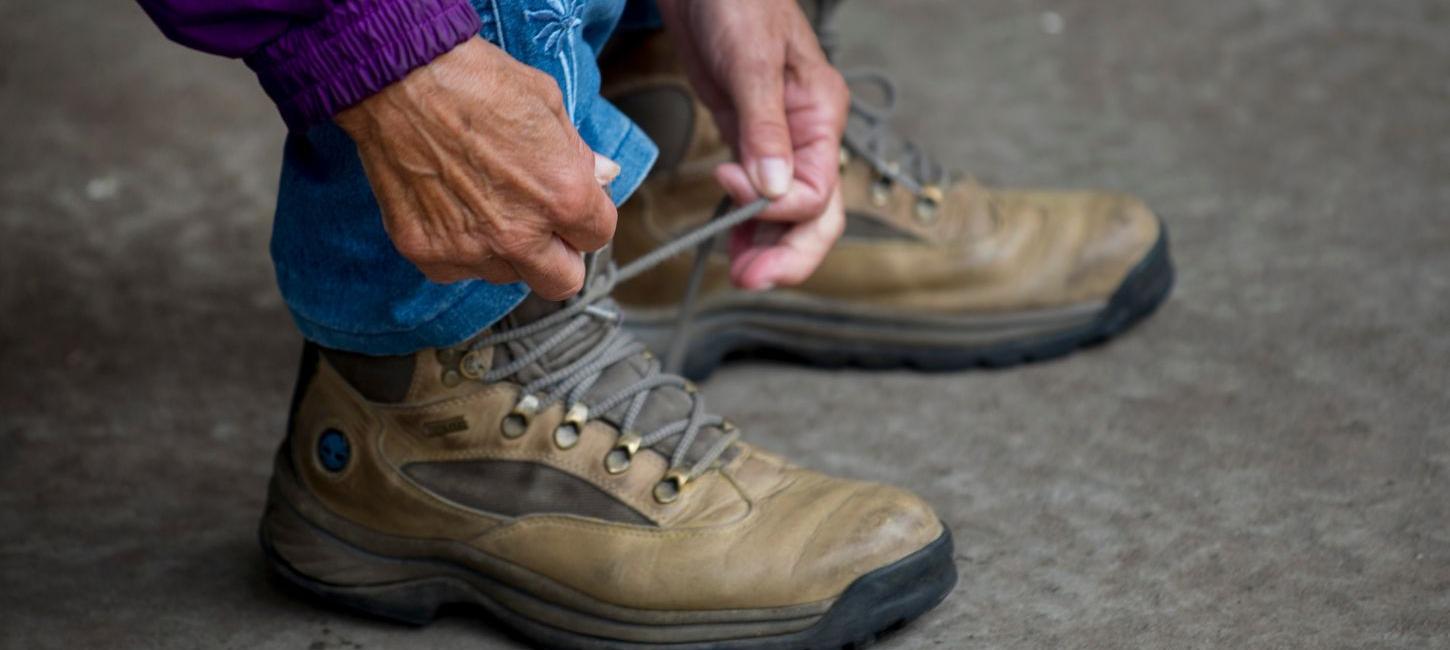 Woman ties her hiking boots and is ready to go for a walk by Vejle