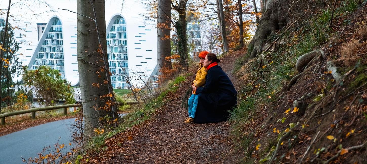 Mother and child on a walk in Nørreskoven in Vejle in autumn with a view of Bølgen and the waterfront