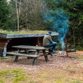 A person is on a shelter trip in Frederikshåb Plantation and makes a bonfire